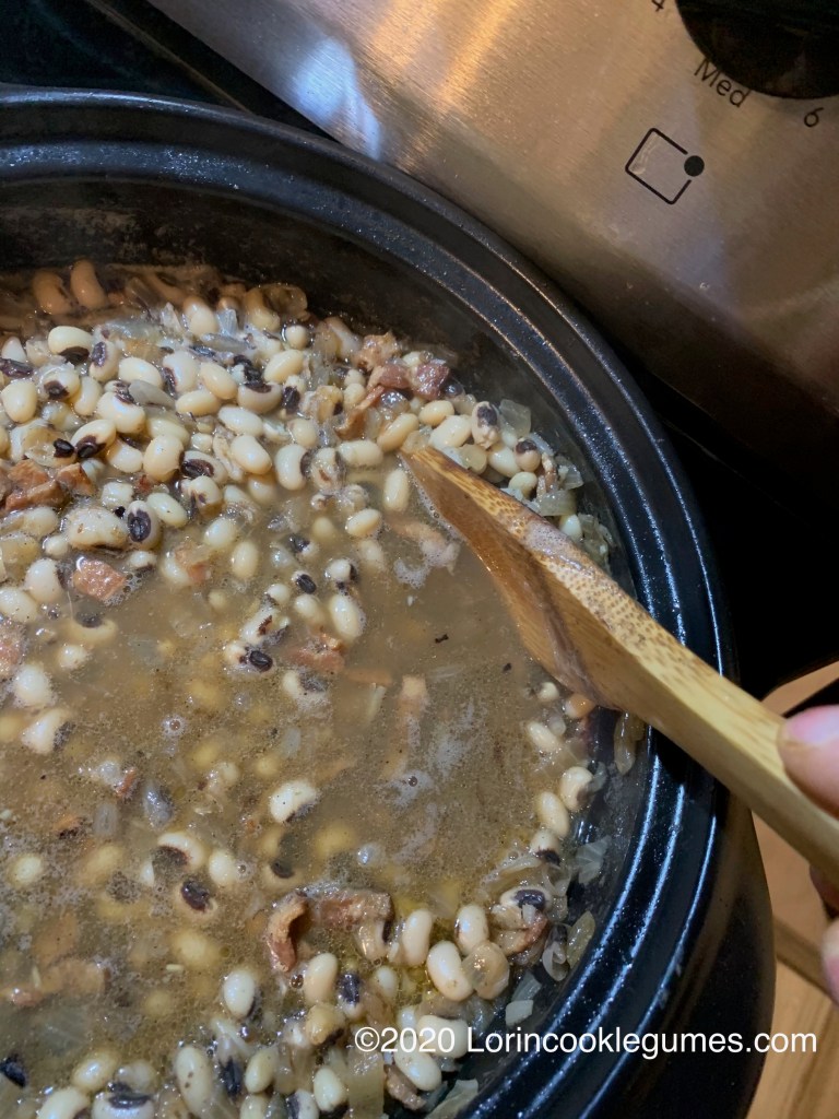 As the beans start to soften, mash some of them against the side of the pot to thicken the broth. 