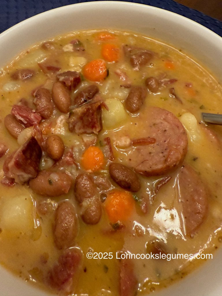 A bowl of Fazulovica, a Slovak bean soup featuring smoked meats, beans, carrots, and potatoes in a creamy broth.