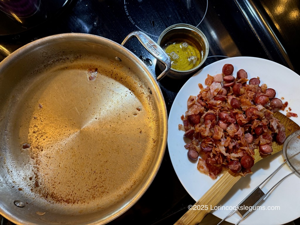 A skillet with remnants of cooking fat, beside a plate of chopped bacon and sliced hot dogs and a can filled with excess fat.