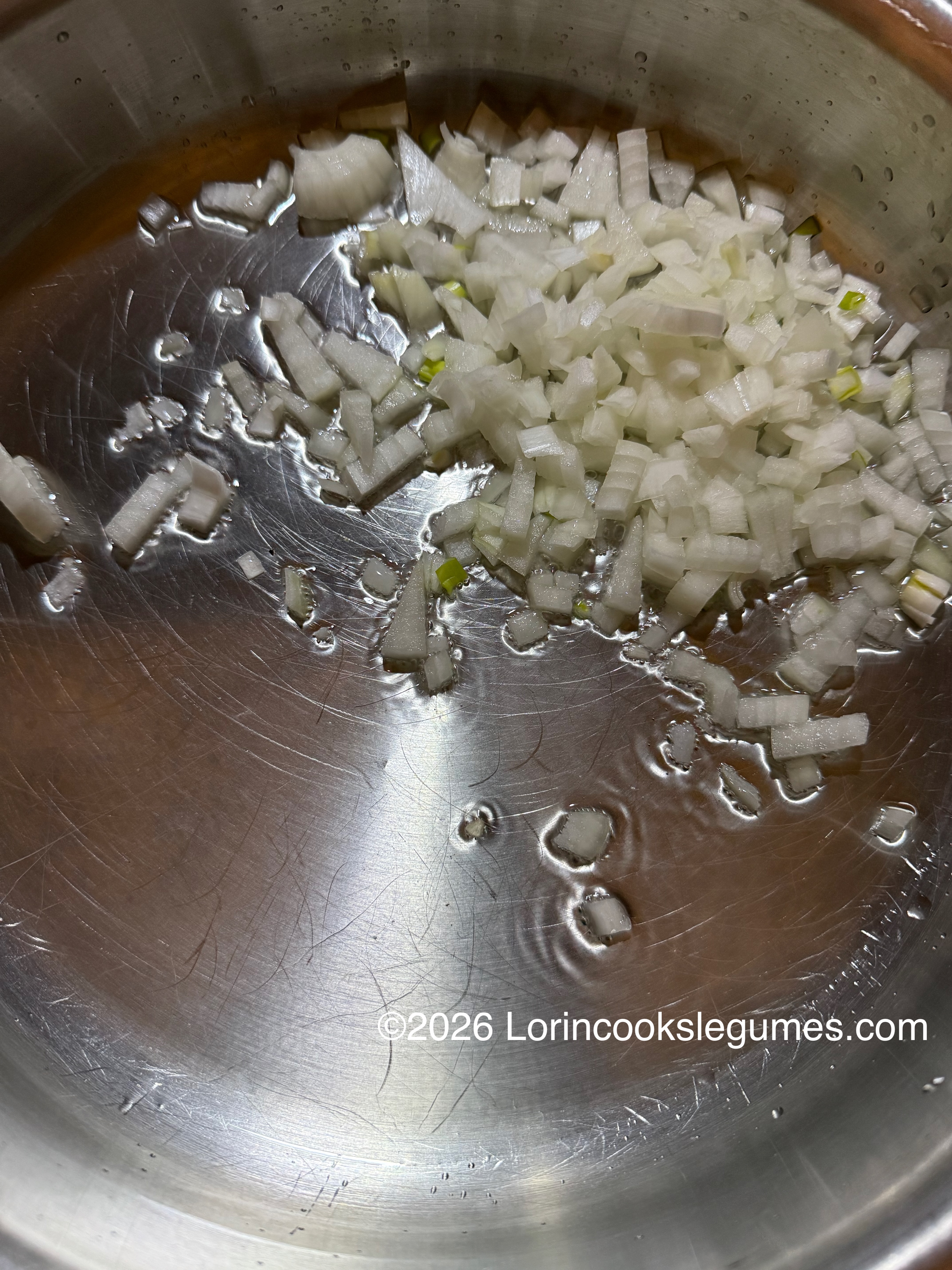 diced white onion sautéing in a pan with oil.