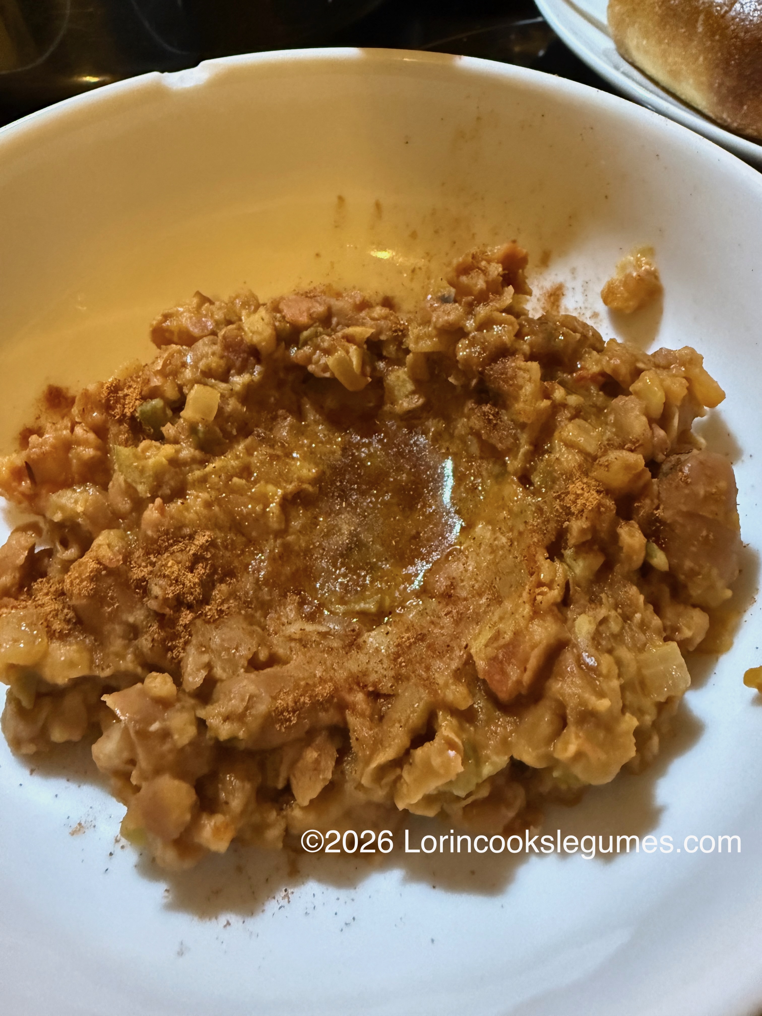 Mashed beans with spices and oil in a white bowl. ©2026 Lorincookslegumes.com