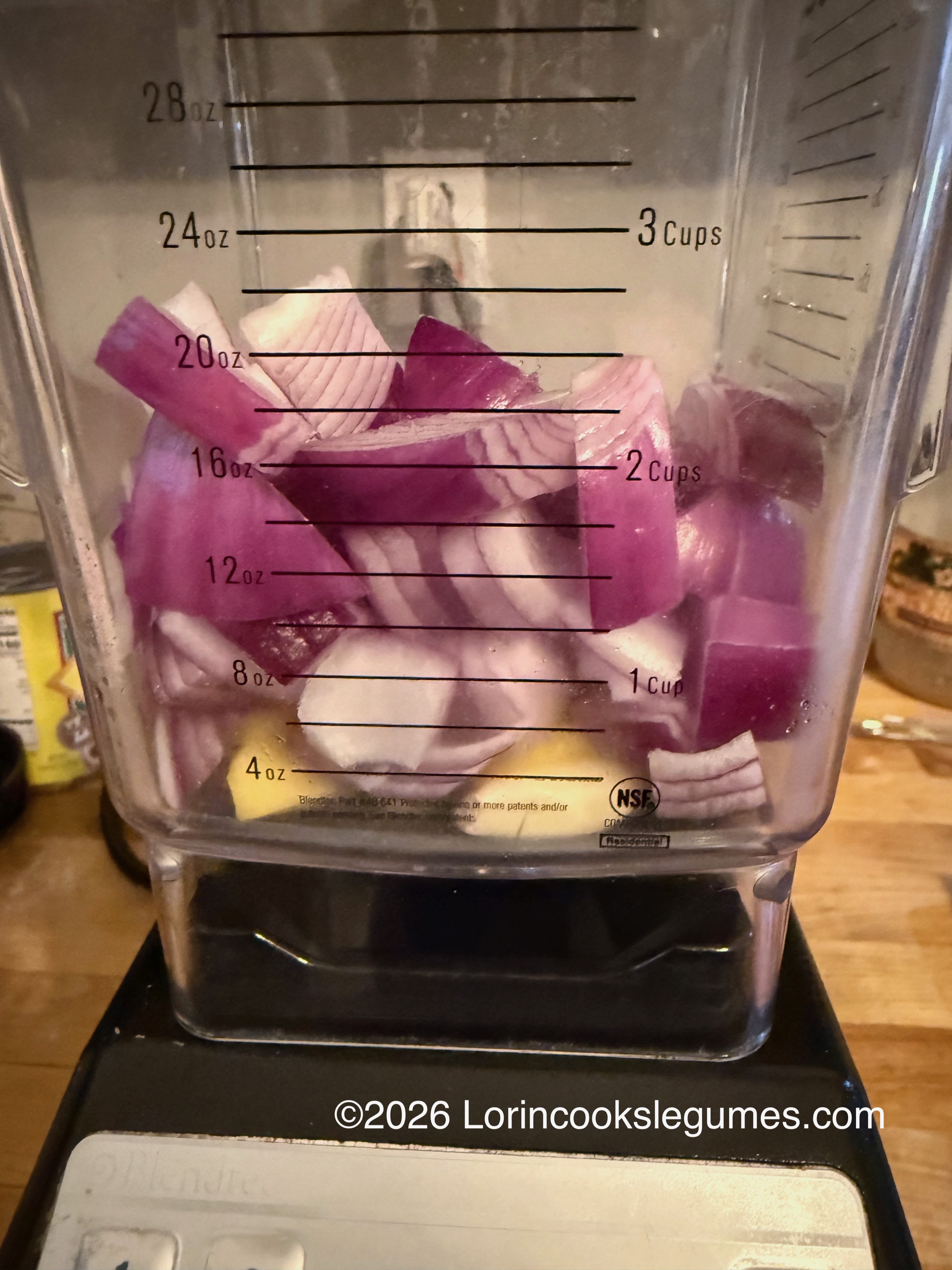Chopped red onions , garlic and ginger, inside a blender jar .