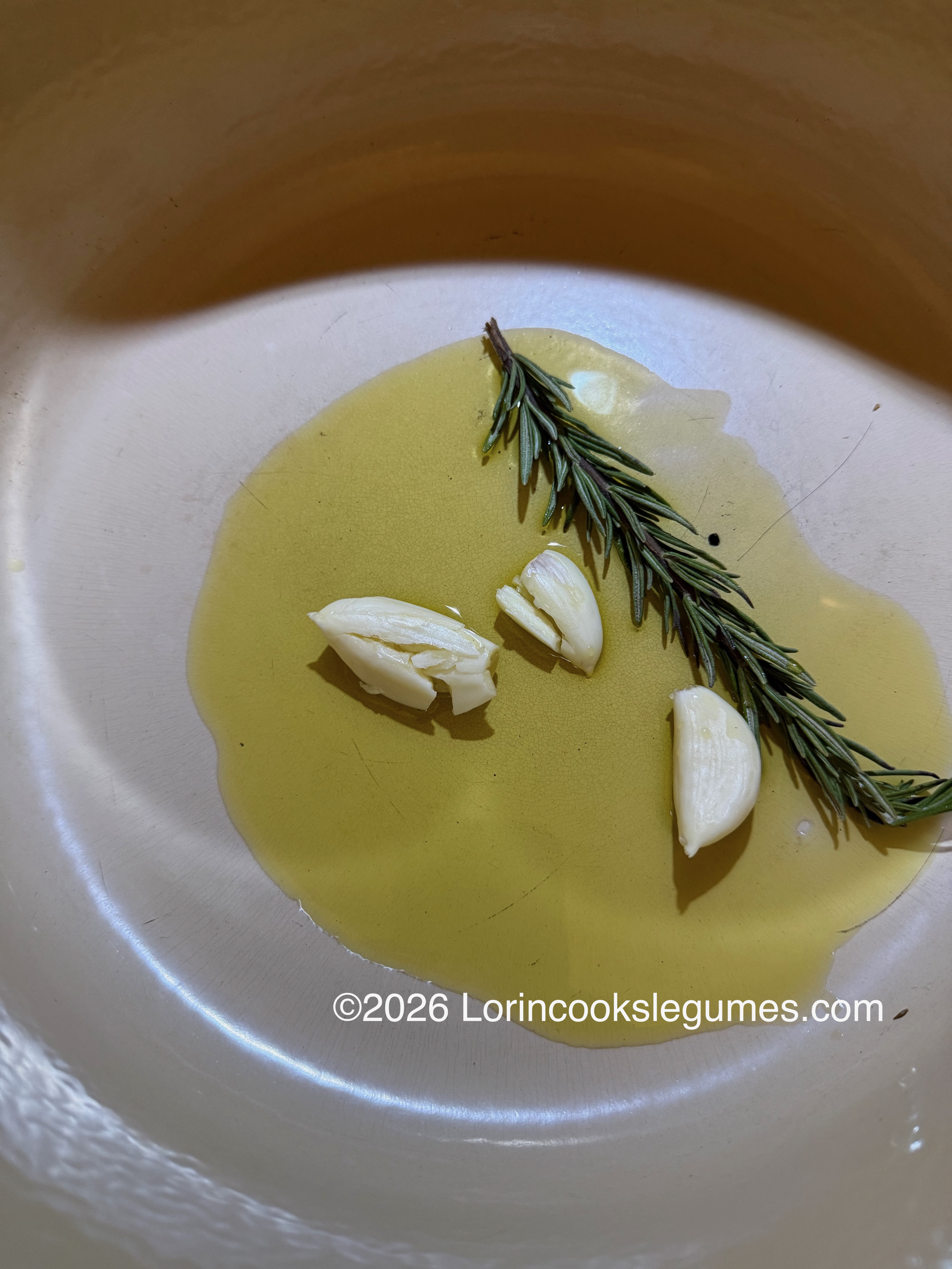 IMG_0212 Close-up of rosemary sprigs and garlic cloves in a pan with olive oil