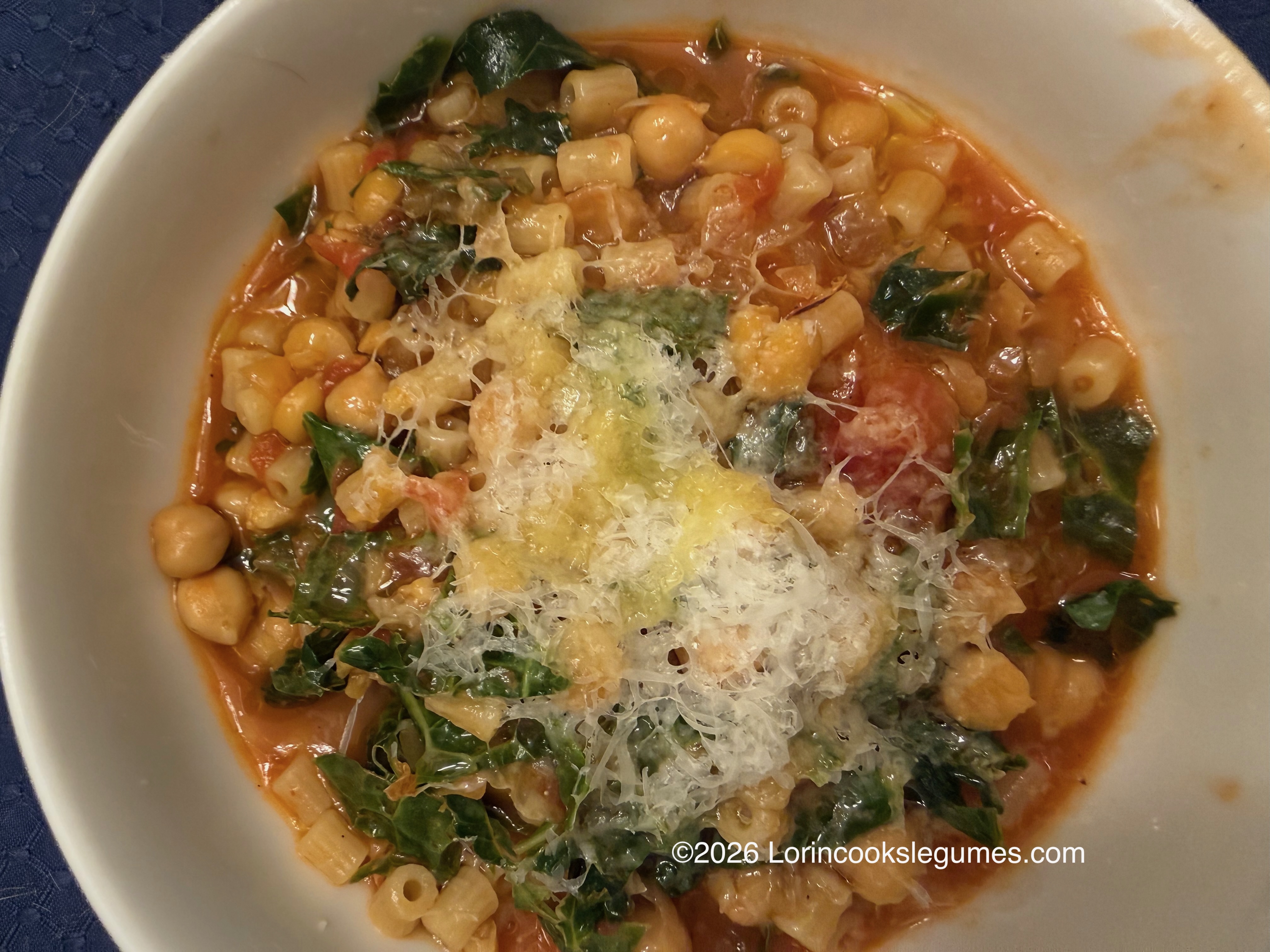 IMG_0237 Close-up of chickpeas and pasta in tomato sauce with kale and grated parmesan.