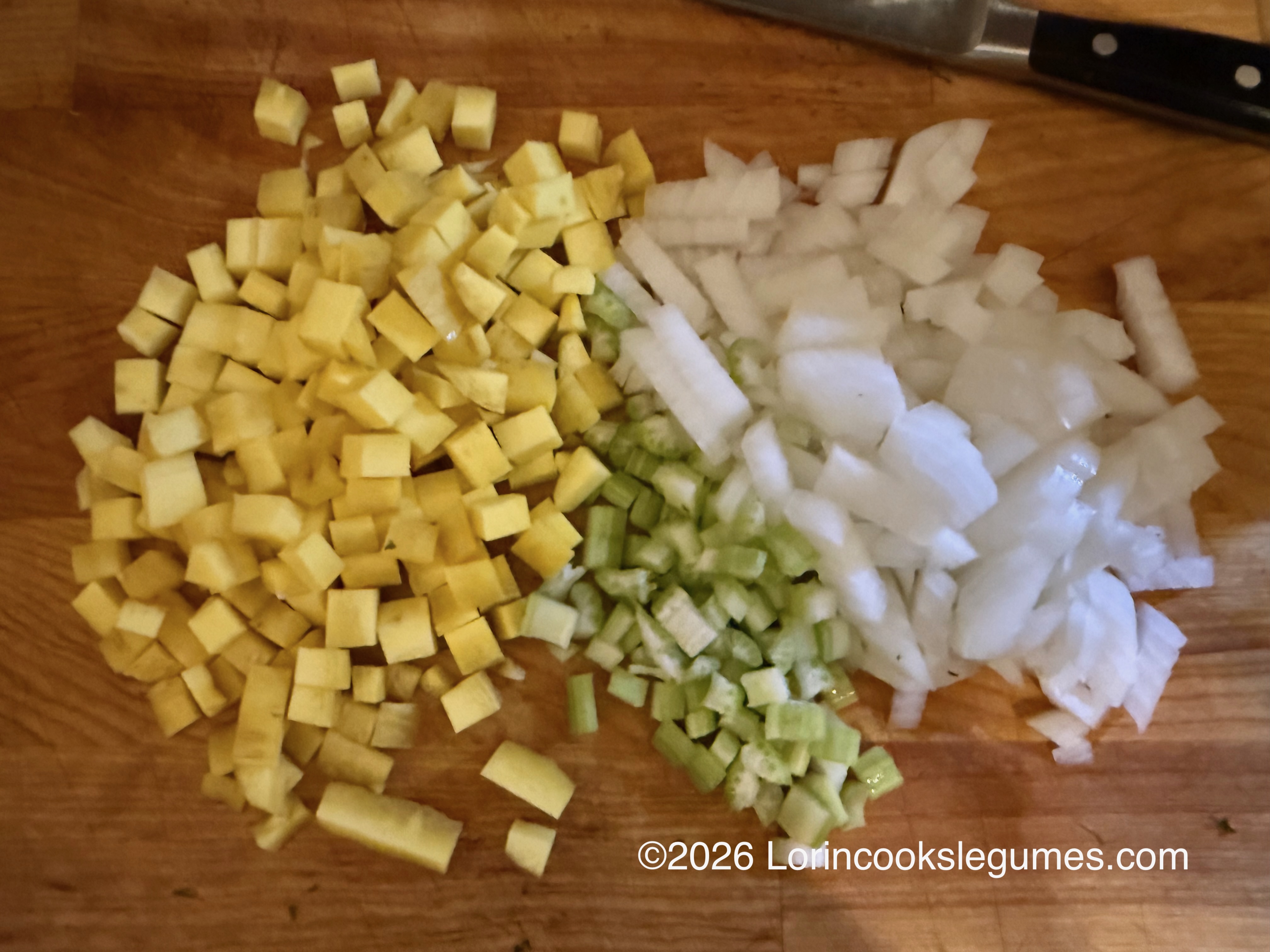 IMG_0265 Diced yellow carrots, white onion, and green celery on a wooden cutting board