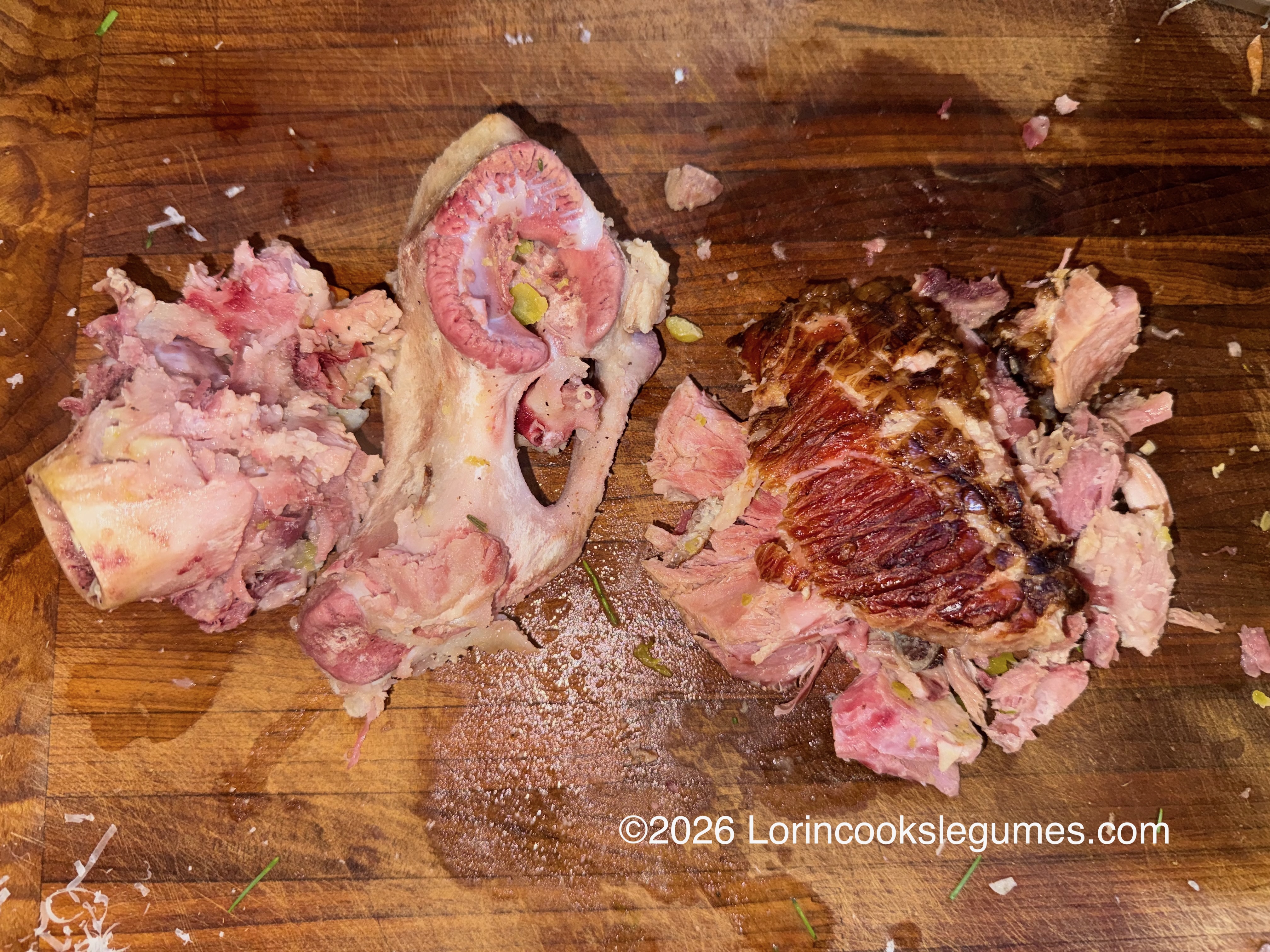 Shredded cooked meat and bones on a wooden cutting board